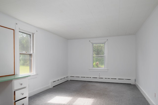 carpeted empty room with a baseboard heating unit