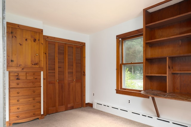 unfurnished bedroom with light colored carpet, a baseboard radiator, a closet, and multiple windows