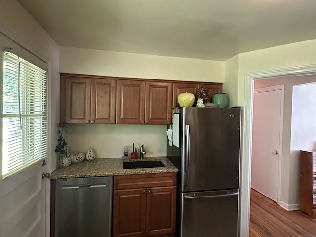 kitchen with appliances with stainless steel finishes, hardwood / wood-style floors, sink, and a wealth of natural light