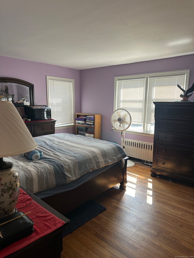 bedroom with radiator and dark hardwood / wood-style floors