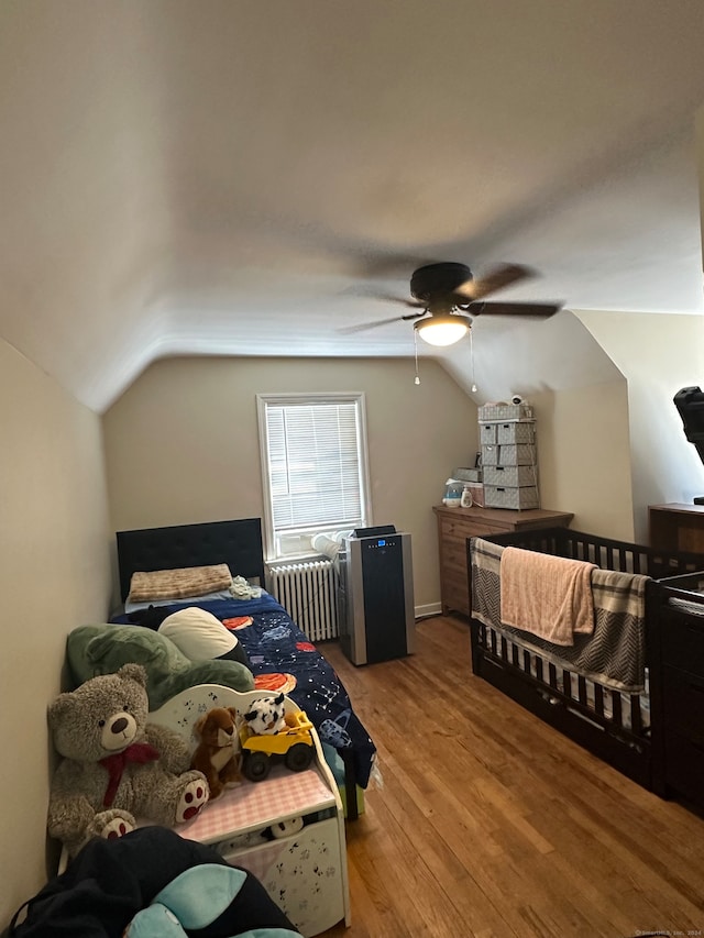 bedroom with radiator, lofted ceiling, ceiling fan, and light wood-type flooring