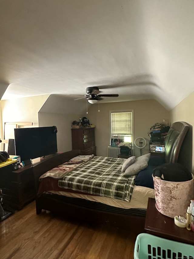 bedroom with wood-type flooring, vaulted ceiling, ceiling fan, and radiator