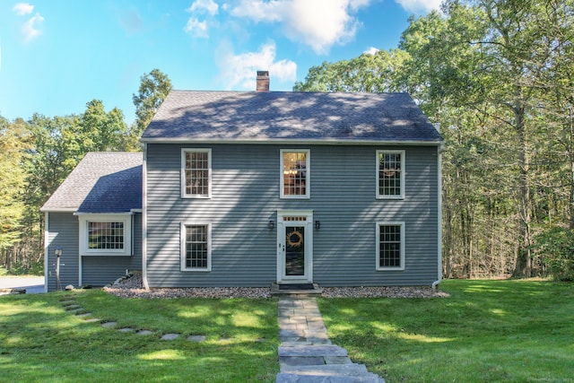 colonial house featuring a front lawn