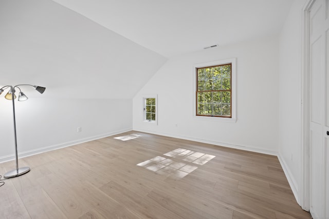 bonus room with vaulted ceiling and light hardwood / wood-style flooring