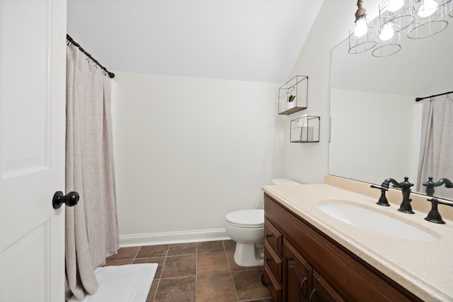 bathroom with lofted ceiling, vanity, and toilet