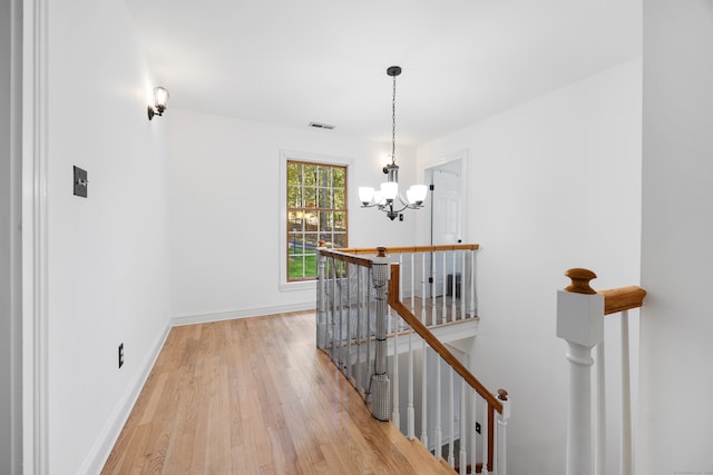 hallway featuring light hardwood / wood-style flooring and a notable chandelier