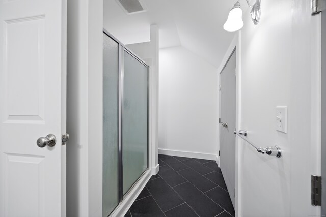 bathroom featuring vaulted ceiling, tile patterned floors, and a shower with shower door