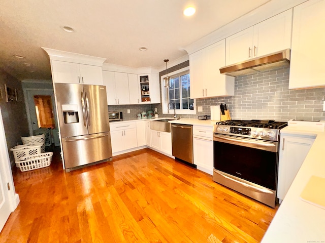 kitchen featuring pendant lighting, white cabinetry, hardwood / wood-style floors, and appliances with stainless steel finishes