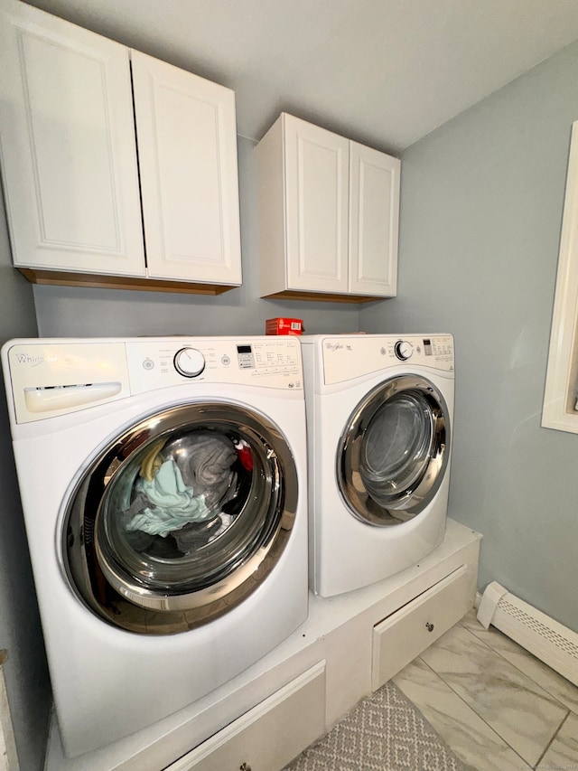 laundry room featuring cabinets, washing machine and dryer, and a baseboard radiator