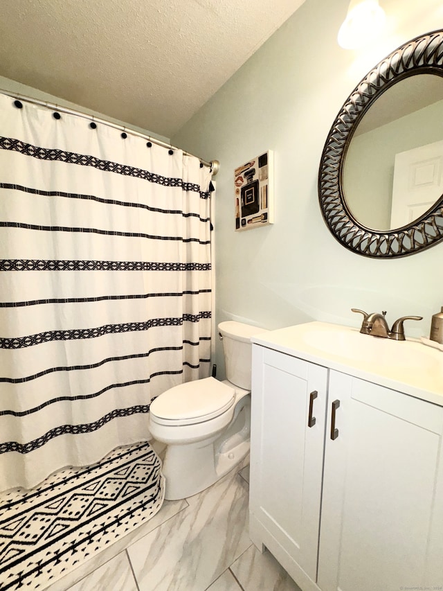 bathroom featuring vanity, toilet, and a textured ceiling