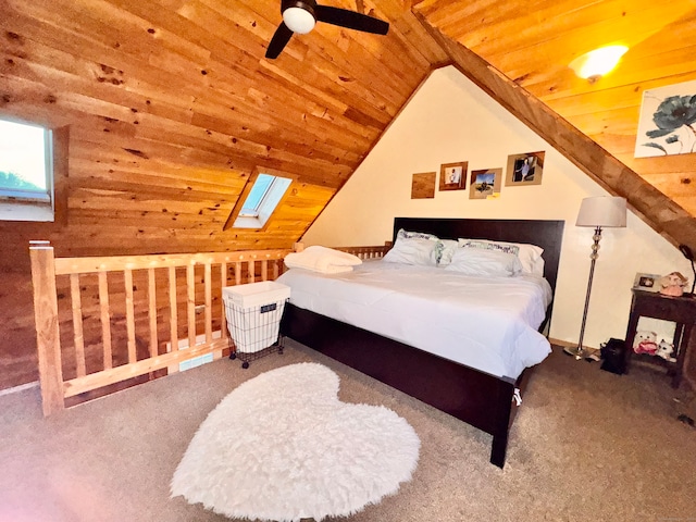 bedroom with carpet, vaulted ceiling with skylight, ceiling fan, and wood ceiling