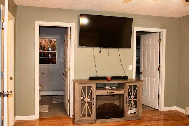 living room featuring hardwood / wood-style floors, a textured ceiling, and a baseboard radiator