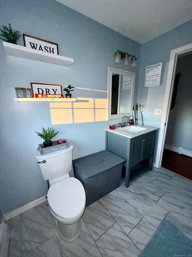 bathroom with a textured ceiling, vanity, toilet, and baseboard heating