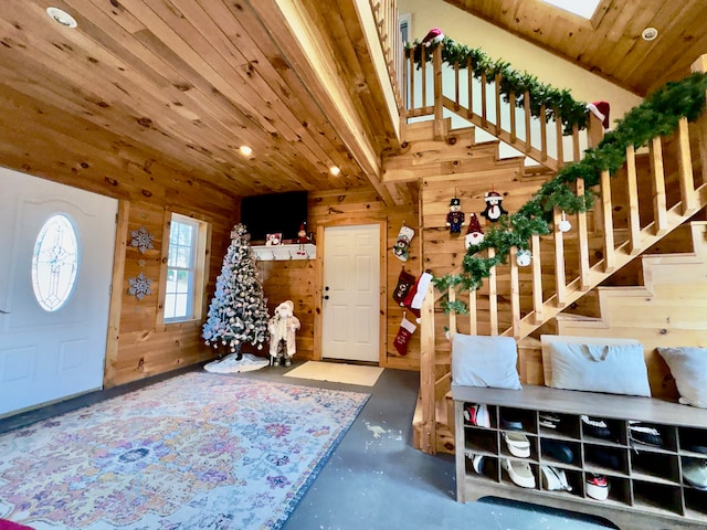 entryway featuring concrete floors, wooden ceiling, and wooden walls