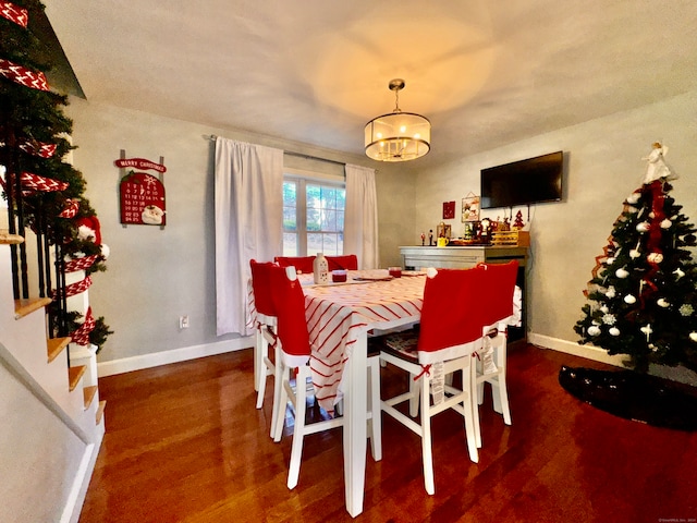 dining space with an inviting chandelier and dark wood-type flooring