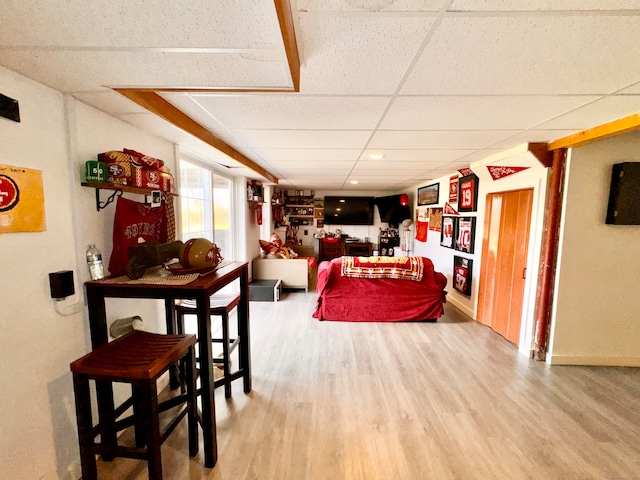 living room with hardwood / wood-style floors and a drop ceiling