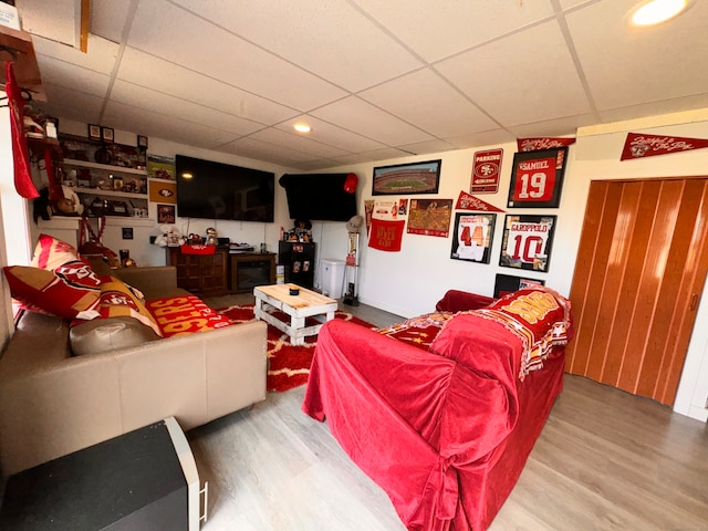 living room with hardwood / wood-style floors and a paneled ceiling