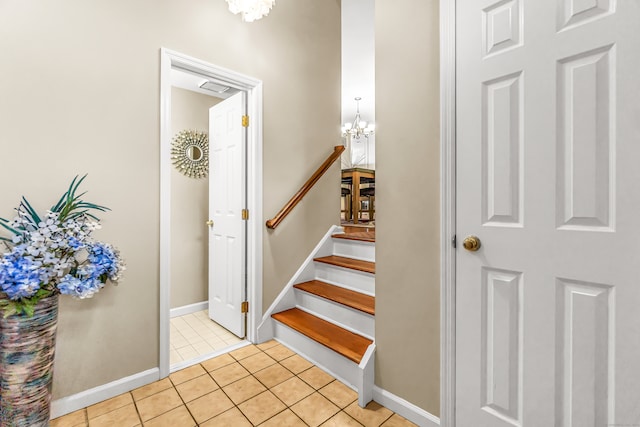 stairway with tile patterned flooring and a chandelier