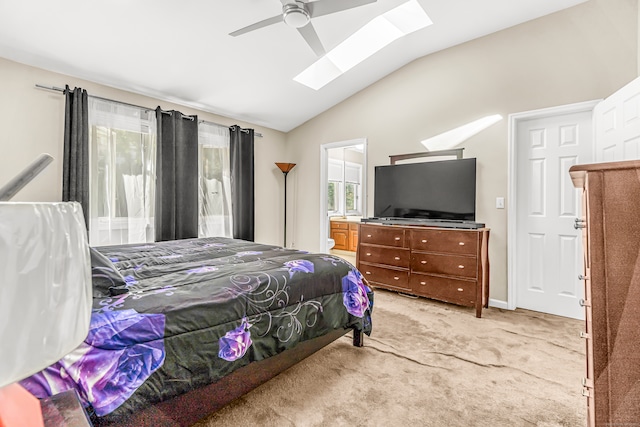 carpeted bedroom with vaulted ceiling with skylight and ceiling fan