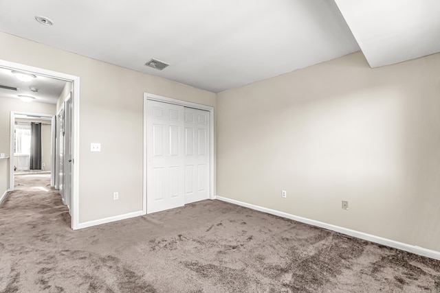 unfurnished bedroom featuring carpet and a closet