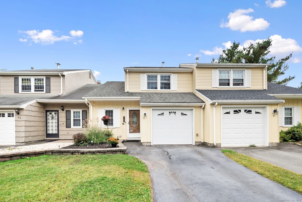 view of front property featuring a garage and a front lawn