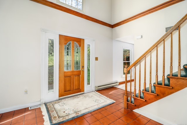 entryway with a baseboard heating unit, a high ceiling, plenty of natural light, and tile patterned flooring