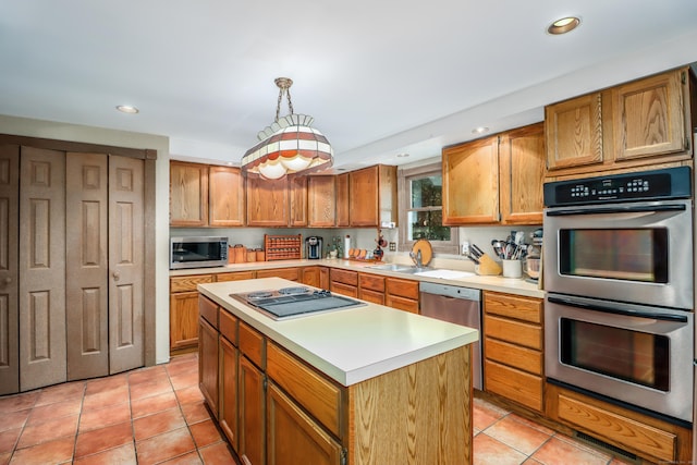 kitchen featuring decorative light fixtures, sink, a center island, light tile patterned floors, and stainless steel appliances