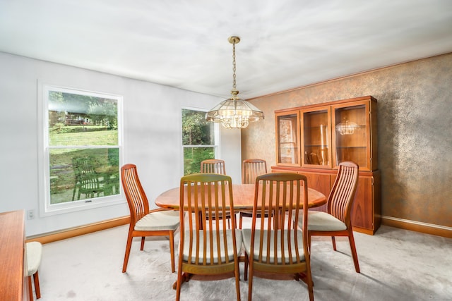 dining room featuring plenty of natural light, light colored carpet, and a chandelier