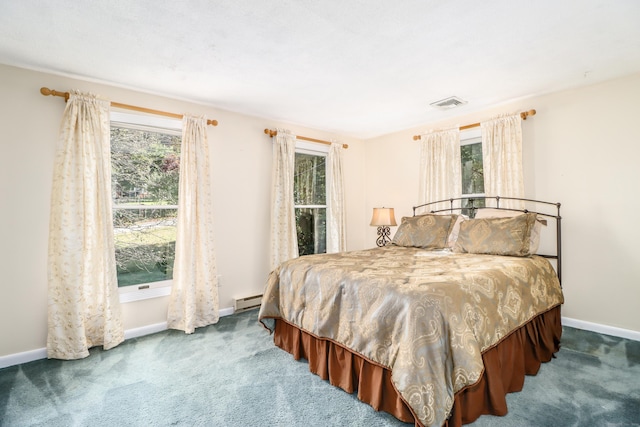 bedroom with carpet and a baseboard heating unit