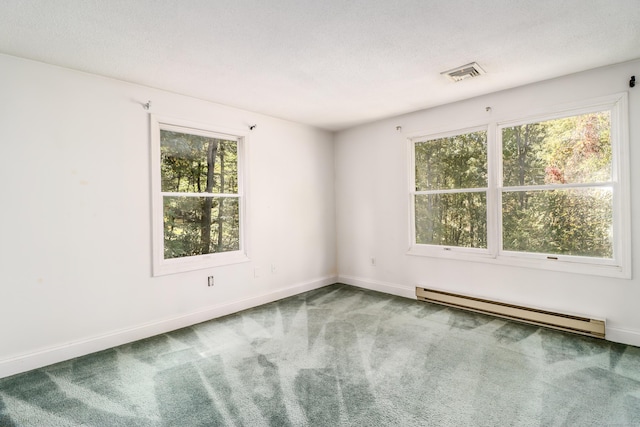 carpeted empty room with a textured ceiling and a baseboard heating unit