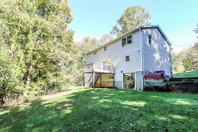 back of property featuring a wooden deck and a yard