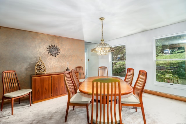 dining area with light carpet and a chandelier