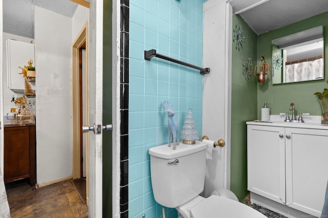 bathroom featuring toilet, tile walls, vanity, and curtained shower