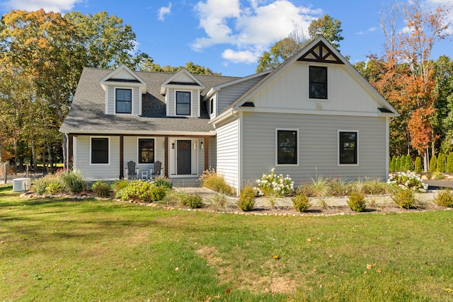 view of front facade featuring a front yard, a porch, and central air condition unit