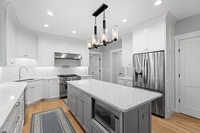 kitchen featuring sink, white cabinets, light wood-type flooring, and appliances with stainless steel finishes