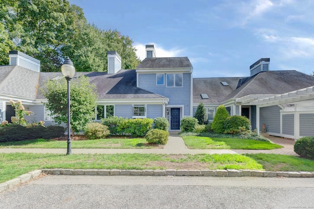 view of front facade with a pergola and a front yard