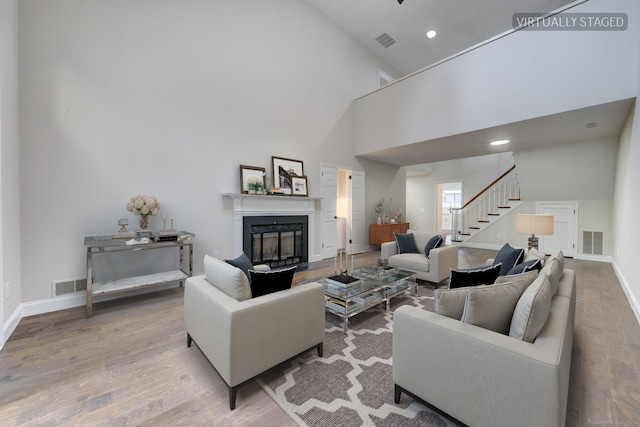 living room with wood-type flooring and high vaulted ceiling