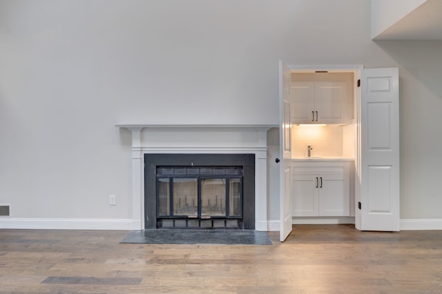 details featuring decorative backsplash, hardwood / wood-style floors, and sink