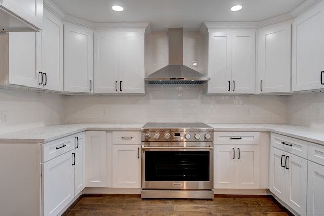 kitchen featuring backsplash, stainless steel range oven, wall chimney exhaust hood, and white cabinetry