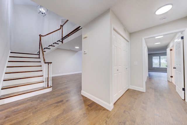 corridor with hardwood / wood-style flooring