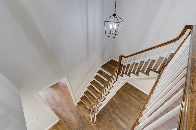 stairway featuring a chandelier and hardwood / wood-style floors