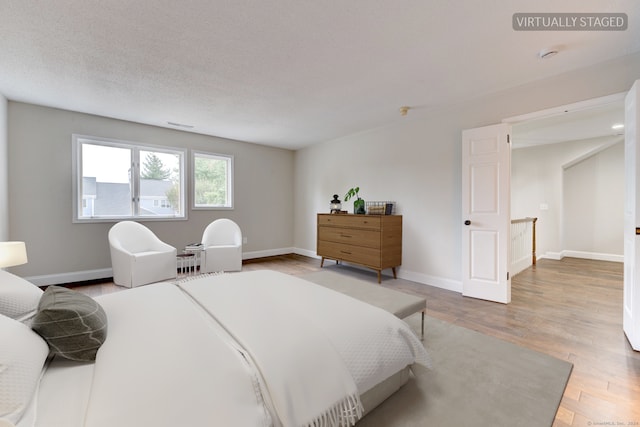 bedroom featuring a textured ceiling and hardwood / wood-style flooring