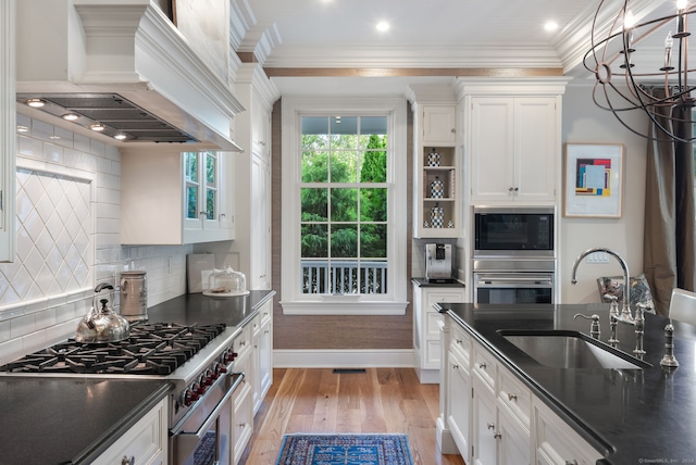 kitchen with light hardwood / wood-style floors, backsplash, stainless steel appliances, custom exhaust hood, and ornamental molding