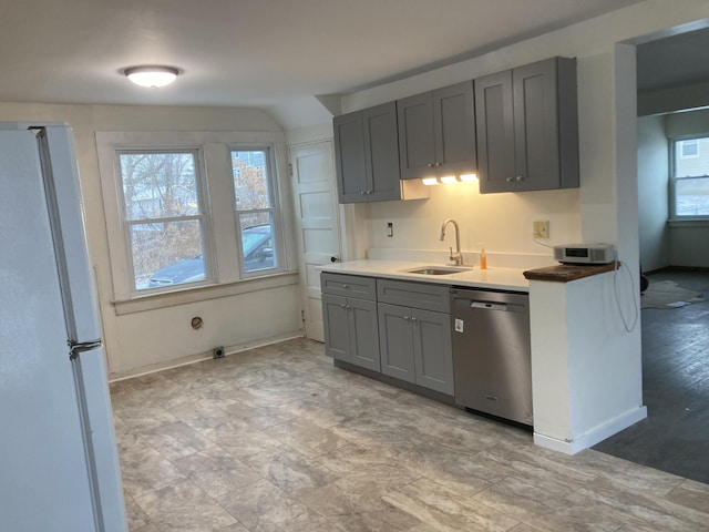 kitchen with dishwasher, white fridge, gray cabinetry, and sink