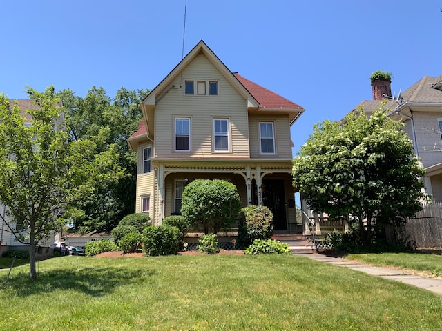 view of property featuring a porch and a front lawn