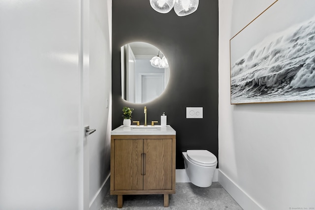 bathroom with vanity, toilet, and concrete floors