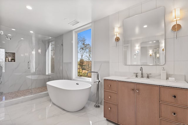 bathroom featuring vanity, tile walls, and plus walk in shower