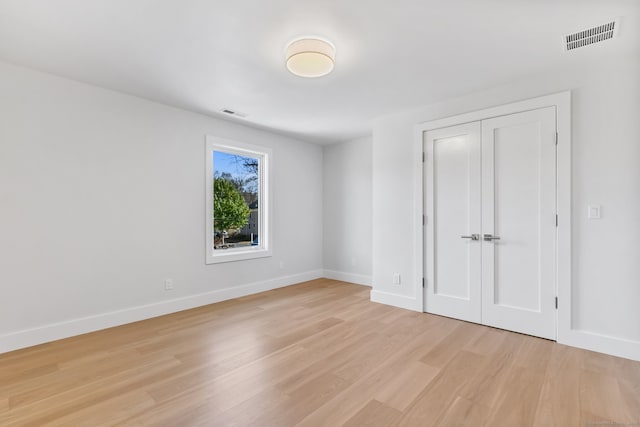 unfurnished bedroom featuring light hardwood / wood-style floors and a closet