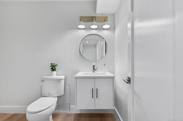 bathroom with hardwood / wood-style floors, vanity, and toilet