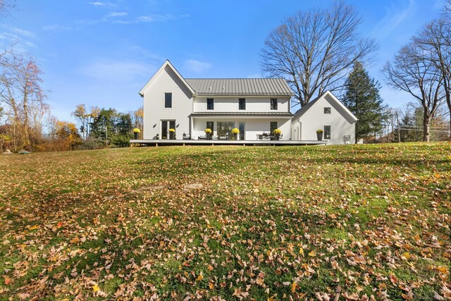 rear view of property featuring a lawn